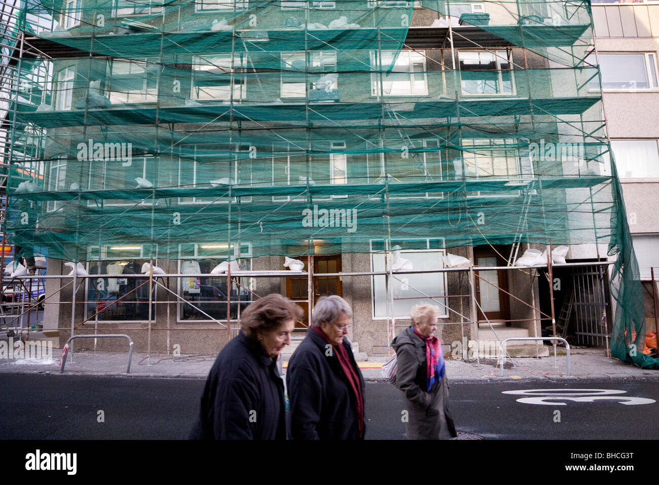 Scaffolding outside a house being repaired, people walking past. Reykjavik Iceland Stock Photo