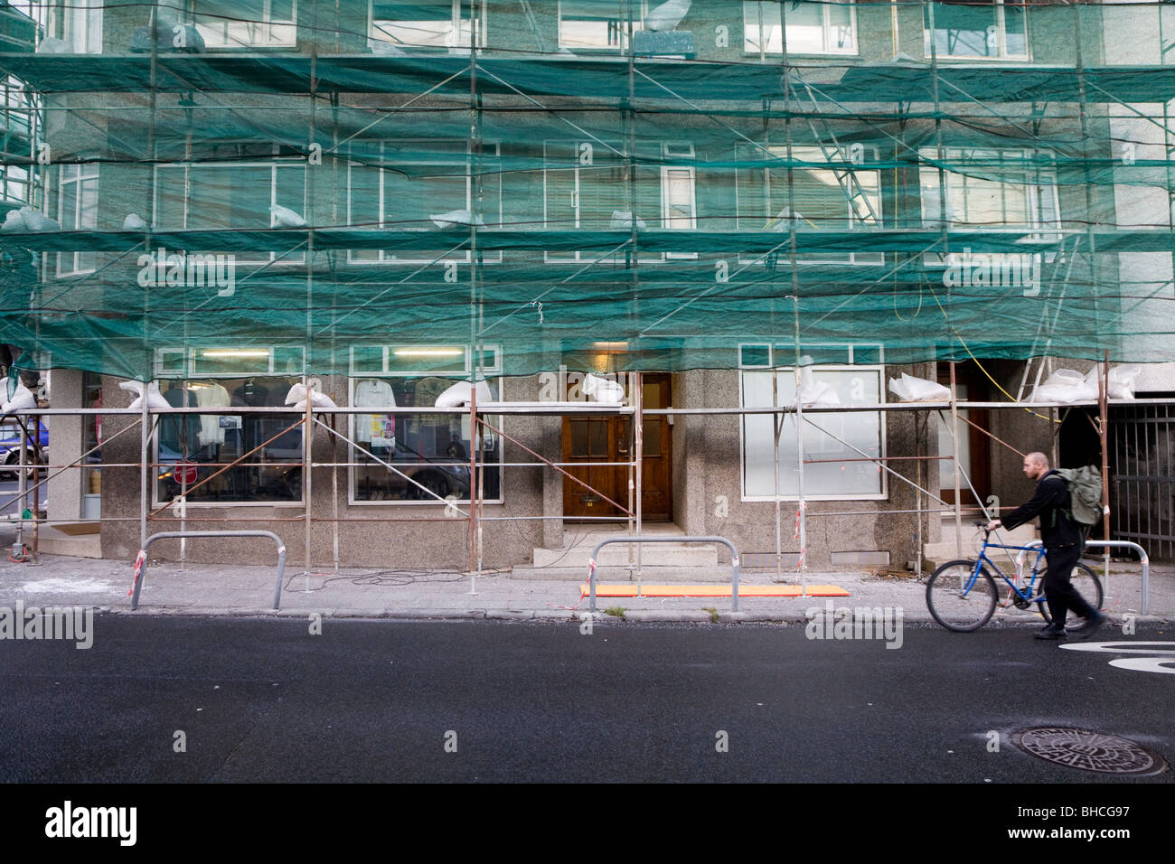Scaffolding outside a house being repaired, man walking past. Reykjavik Iceland Stock Photo