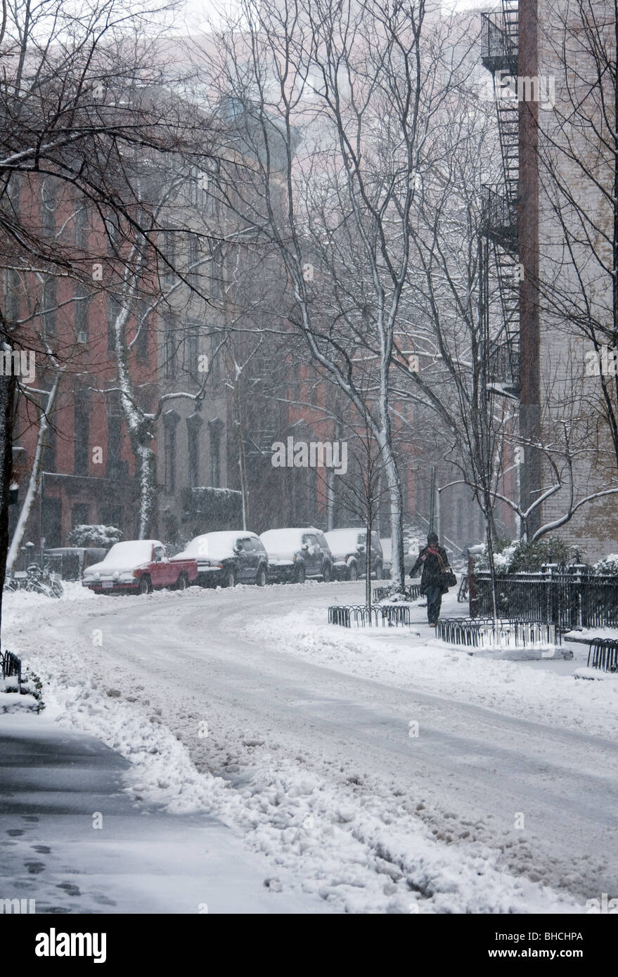 Woman walking through snow covered street in Greenwich Village area of New York as blizzard bad weather is about to get worse. Stock Photo
