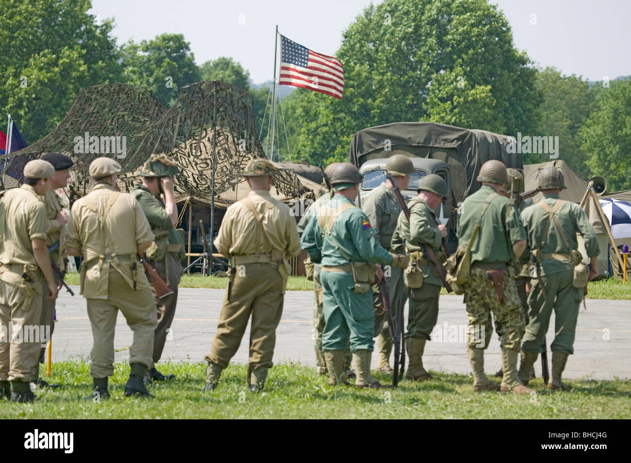 American soldiers with American flag flying in background at Mid-Atlantic Air Museum World War II Weekend and Reenactment in Rea Stock Photo