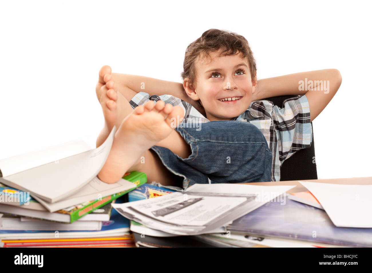 Portrait of a barefoot schoolboy with his feet up on his desk, waiting