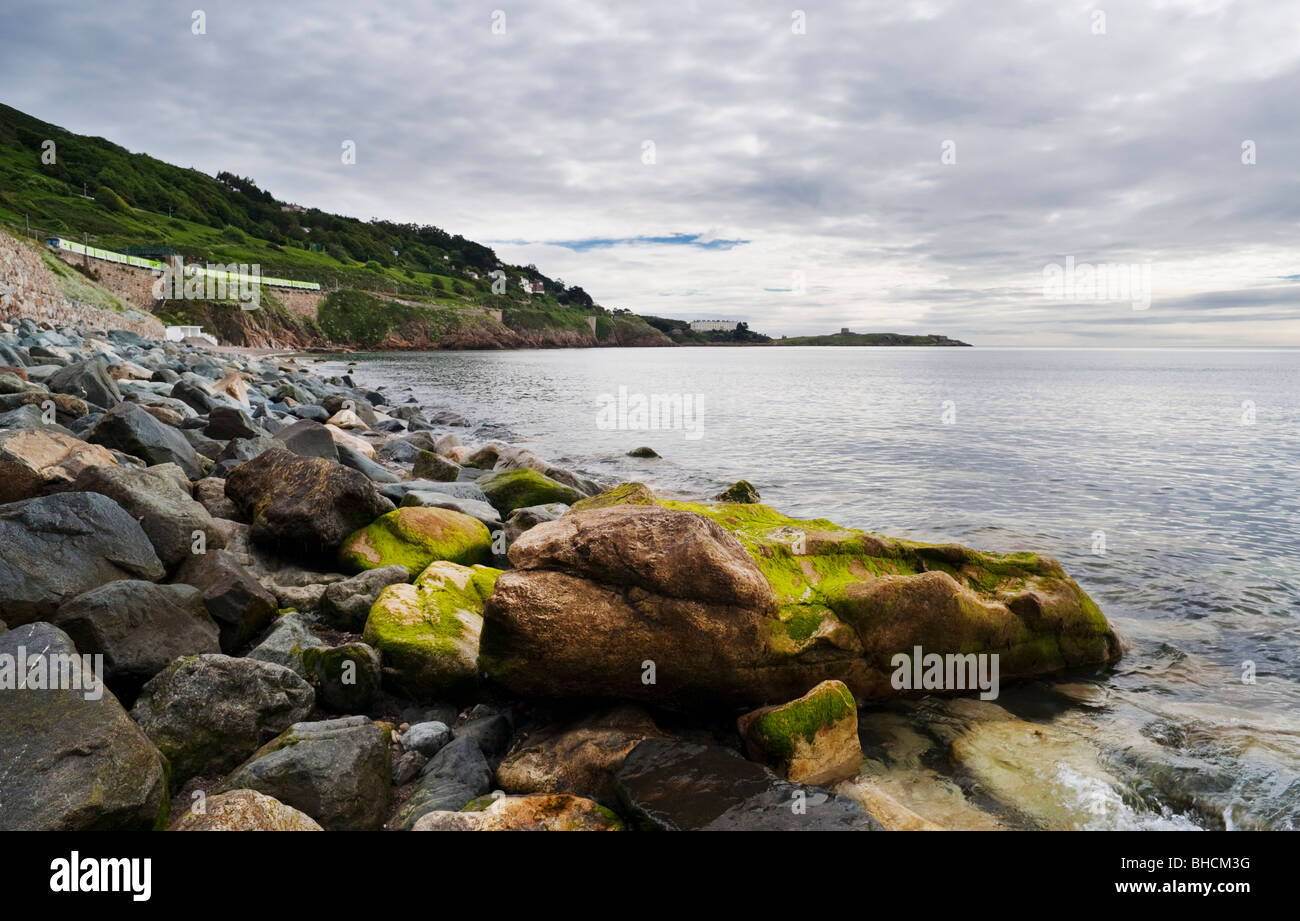 View northwards over Killiney Bay, Dublin, Ireland, from White Rock Beach, with Dublin DART train in the background Stock Photo