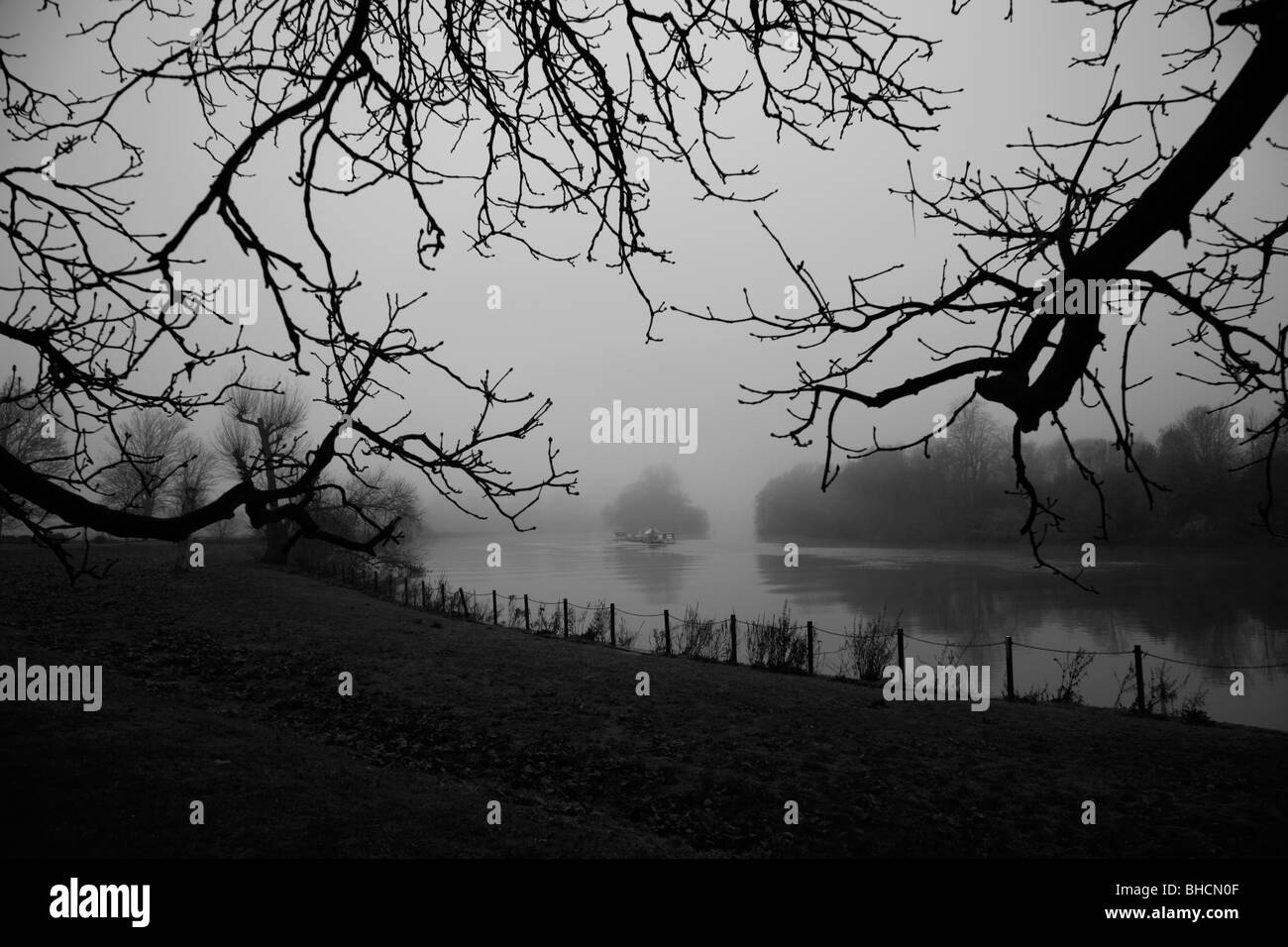 Looking out from Buccleugh Gardens to a misty Glovers Island in the middle of a River Thames, Petersham, London, UK Stock Photo