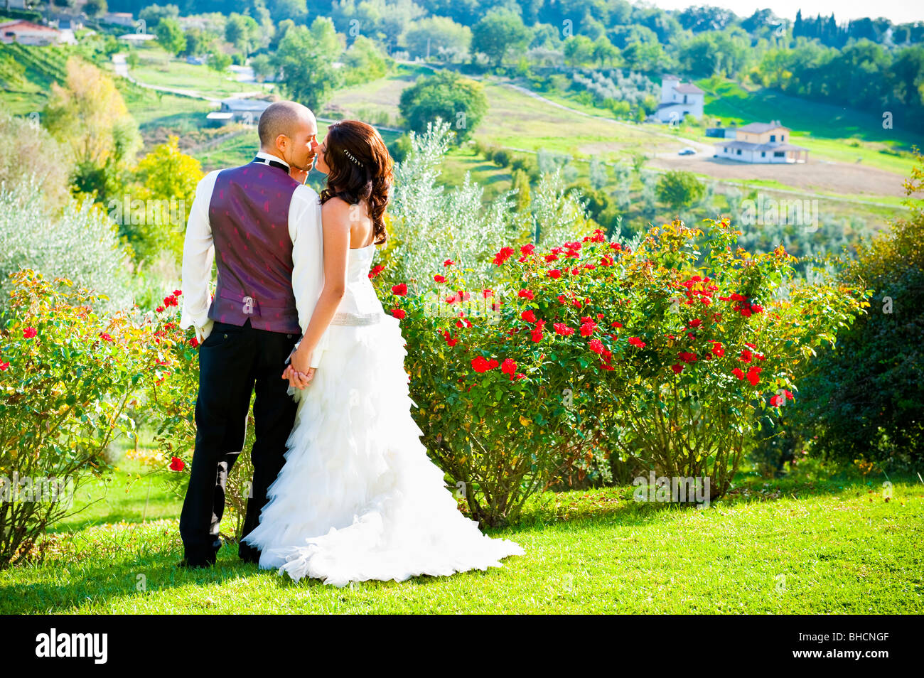 Bride and groom kissing in garden Stock Photo - Alamy