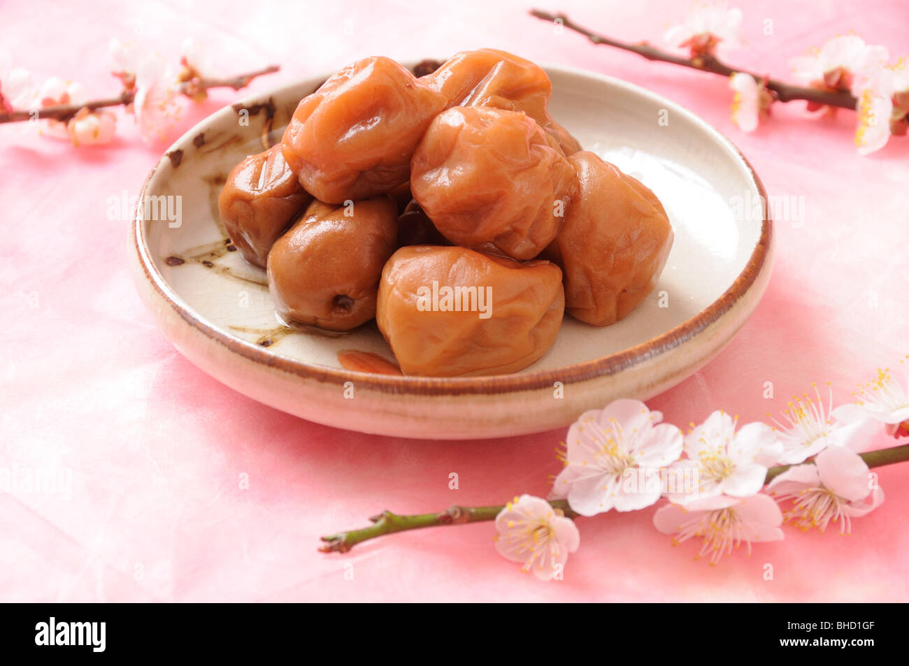 Pickled plums in dish next to plum blossoms Stock Photo - Alamy
