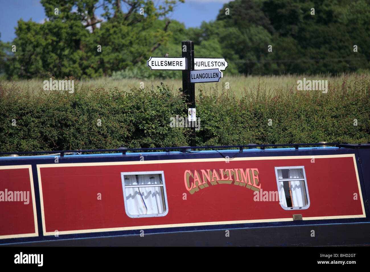 Sign at the junction of the Llangollen canal and the Ellesmere arm with a Canaltime narrowboat in the foreground Stock Photo