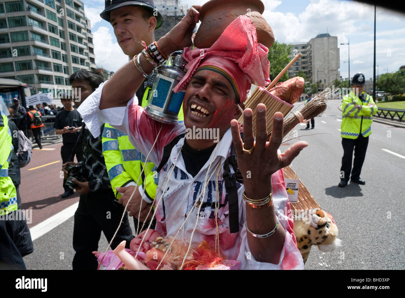 'March for Imprisoned Tamils' London 20 June 2009. Man with jug on head and police Stock Photo