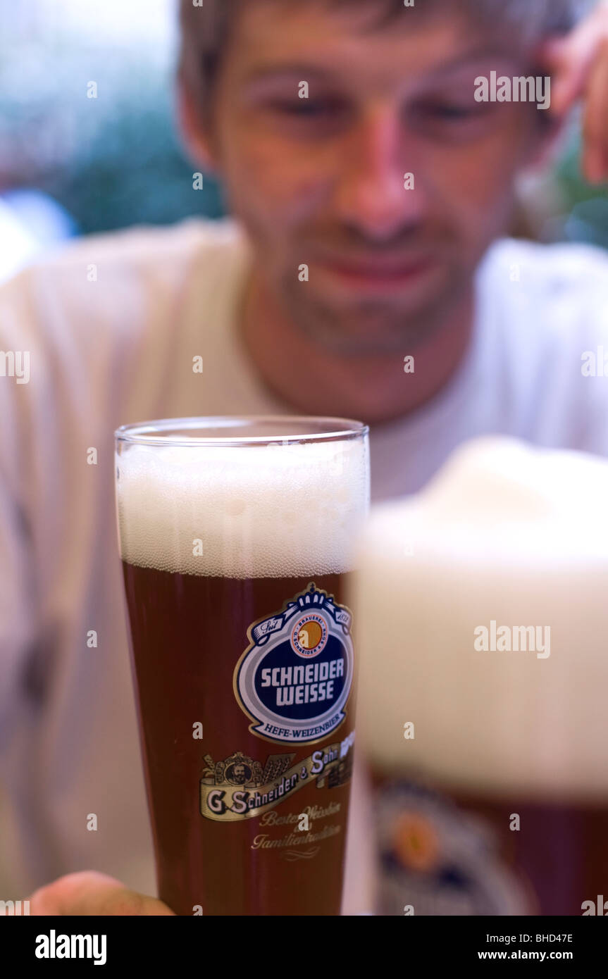 https://c8.alamy.com/comp/BHD47E/a-young-man-looking-at-a-glass-of-schneider-weisse-wheat-beer-BHD47E.jpg