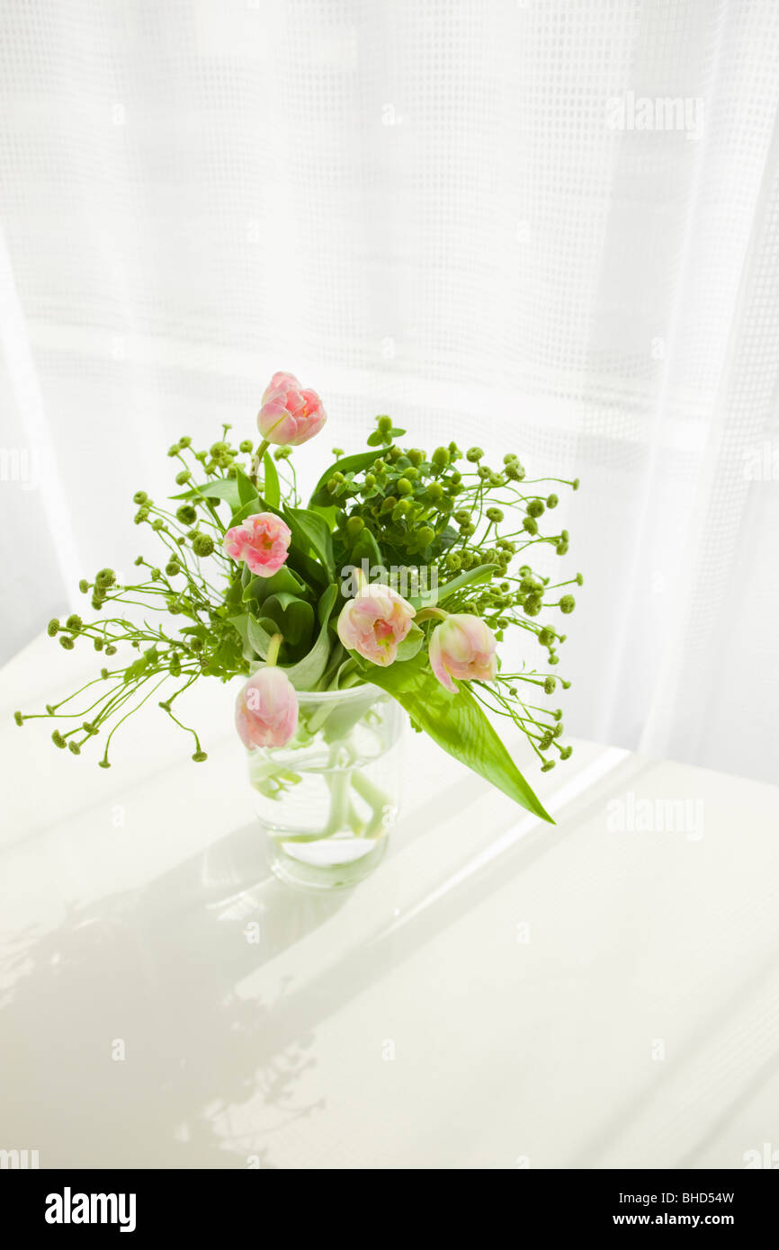 Vase of pink tulips on table Stock Photo