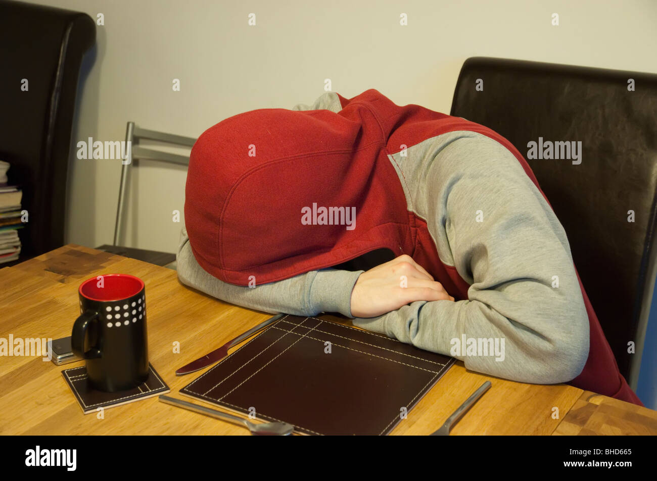 A hooded youth recovering from a hangover. Stock Photo