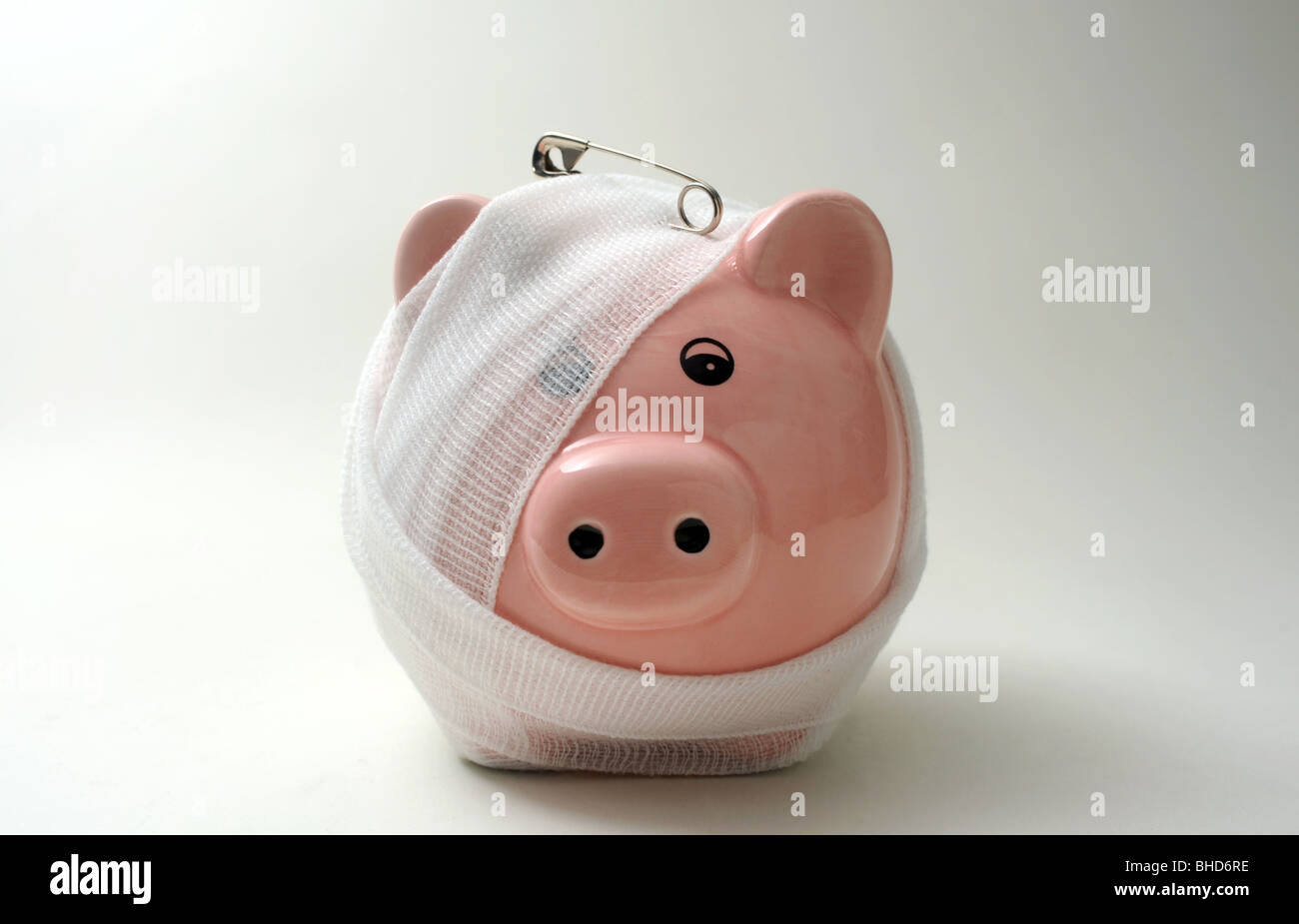 BANDAGED/INJURED PIGGYBANK WITH SAFETY PIN RE FINANCE LOANS CASH MONEY SAVINGS PIGGY BANK BANKS MORTGAGES INCOMES WAGES UK ETC Stock Photo