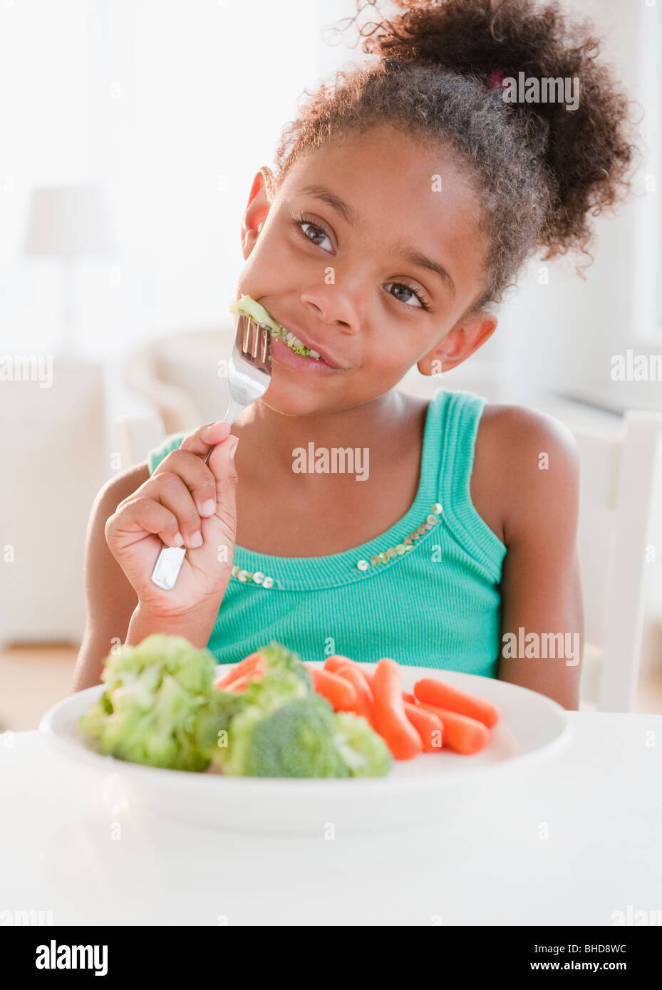 Mixed race girl eating healthy meal Stock Photo
