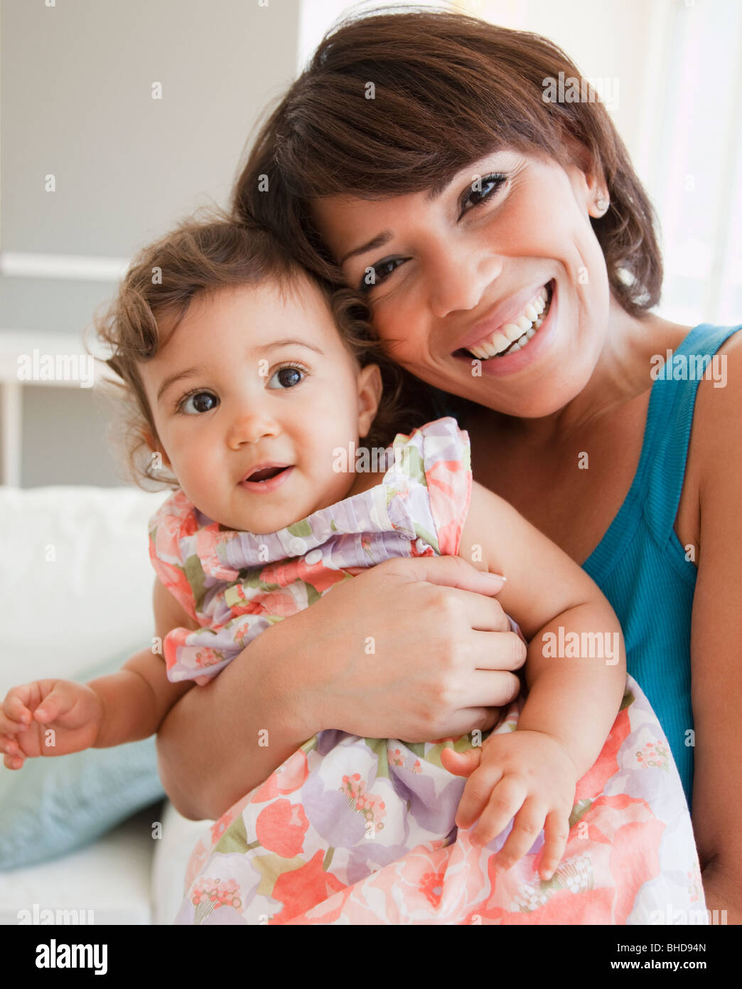 Hispanic mother holding baby girl Stock Photo - Alamy, image size:1044x1390