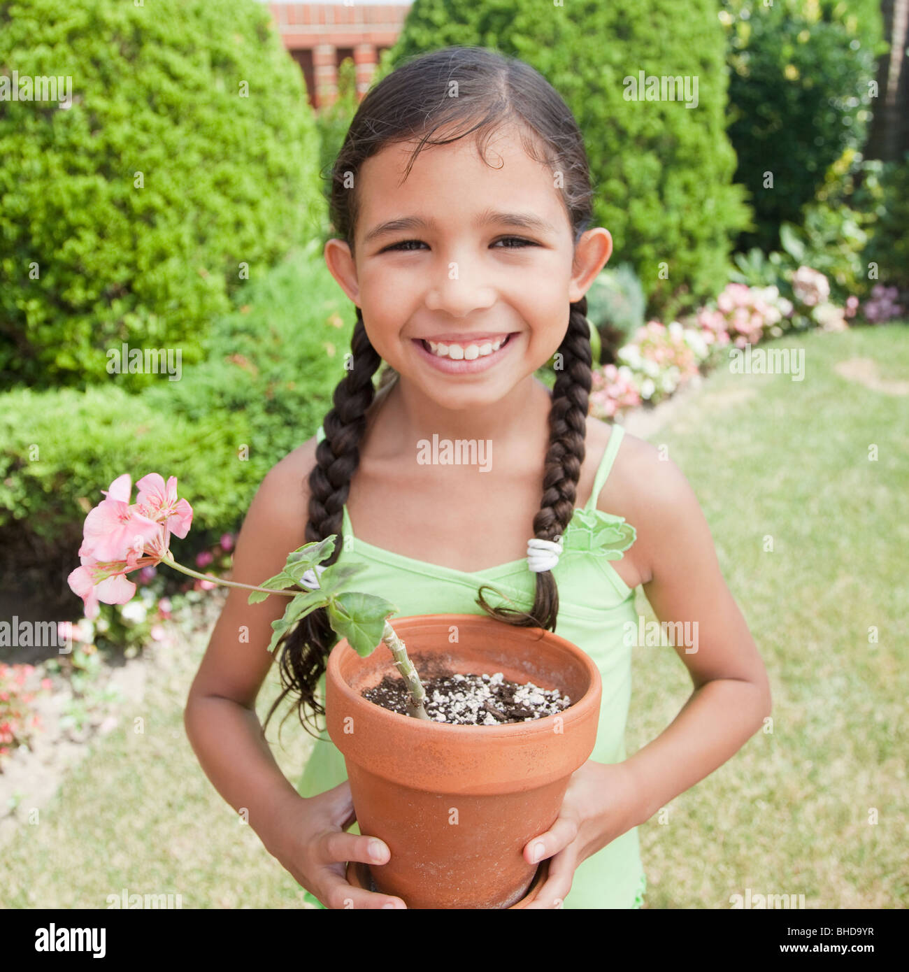 Hispanic girl holding potted plant Stock Photo