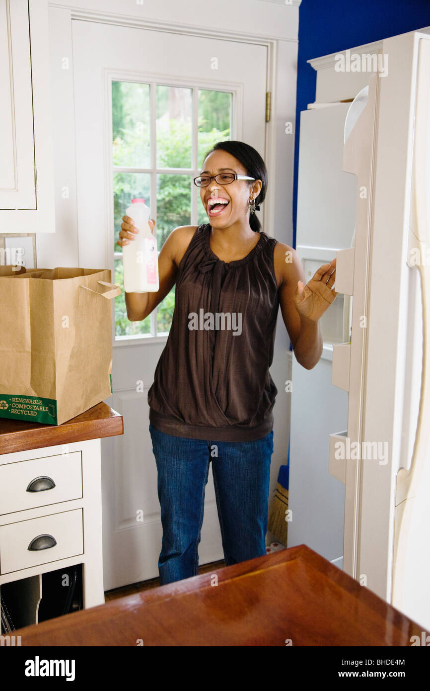 African woman unloading groceries in kitchen Stock Photo