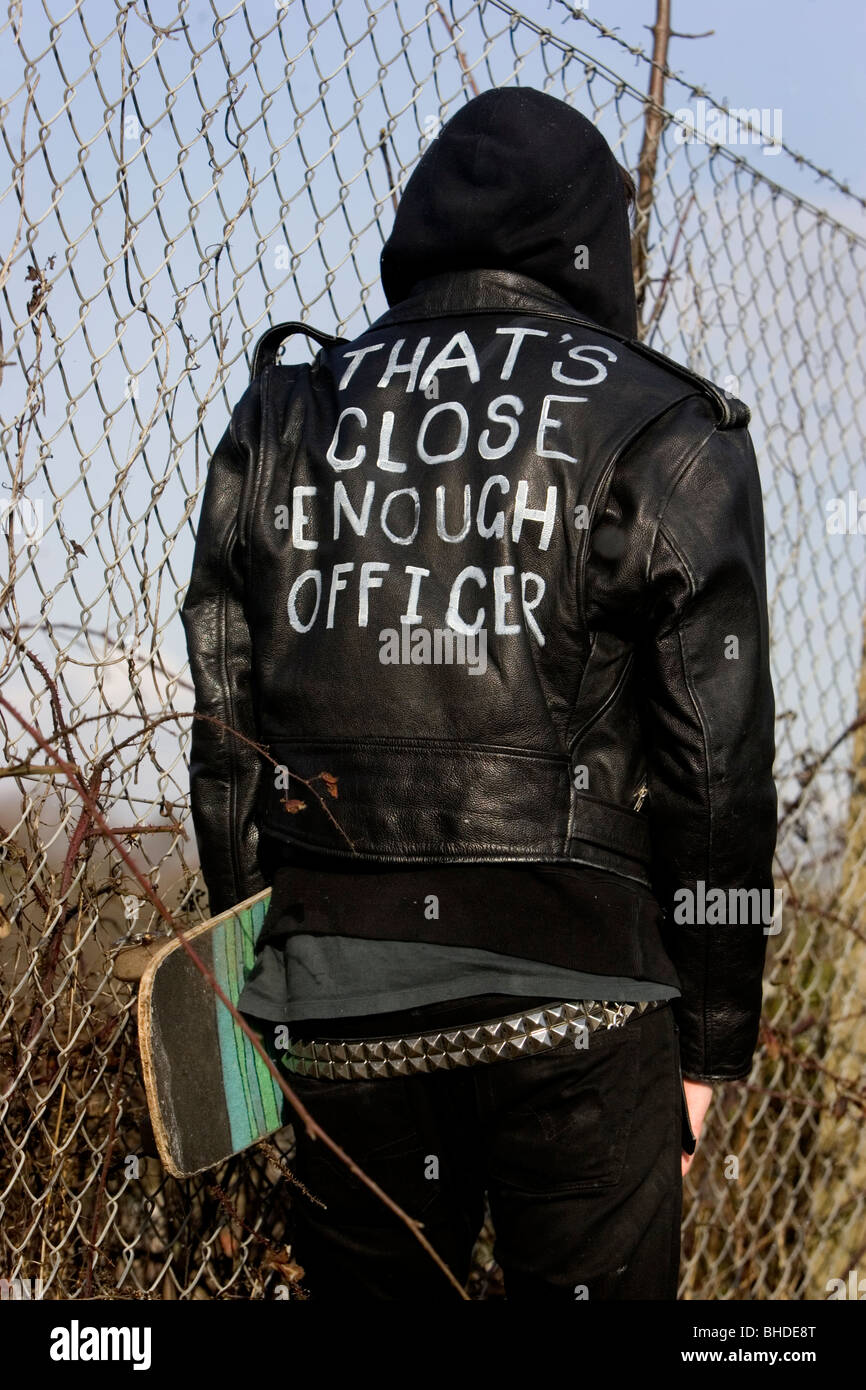 Modern Punk Skate border pictured wearing a black leather jacket which reads 'That's close enough officer' on the reverse, UK. Stock Photo