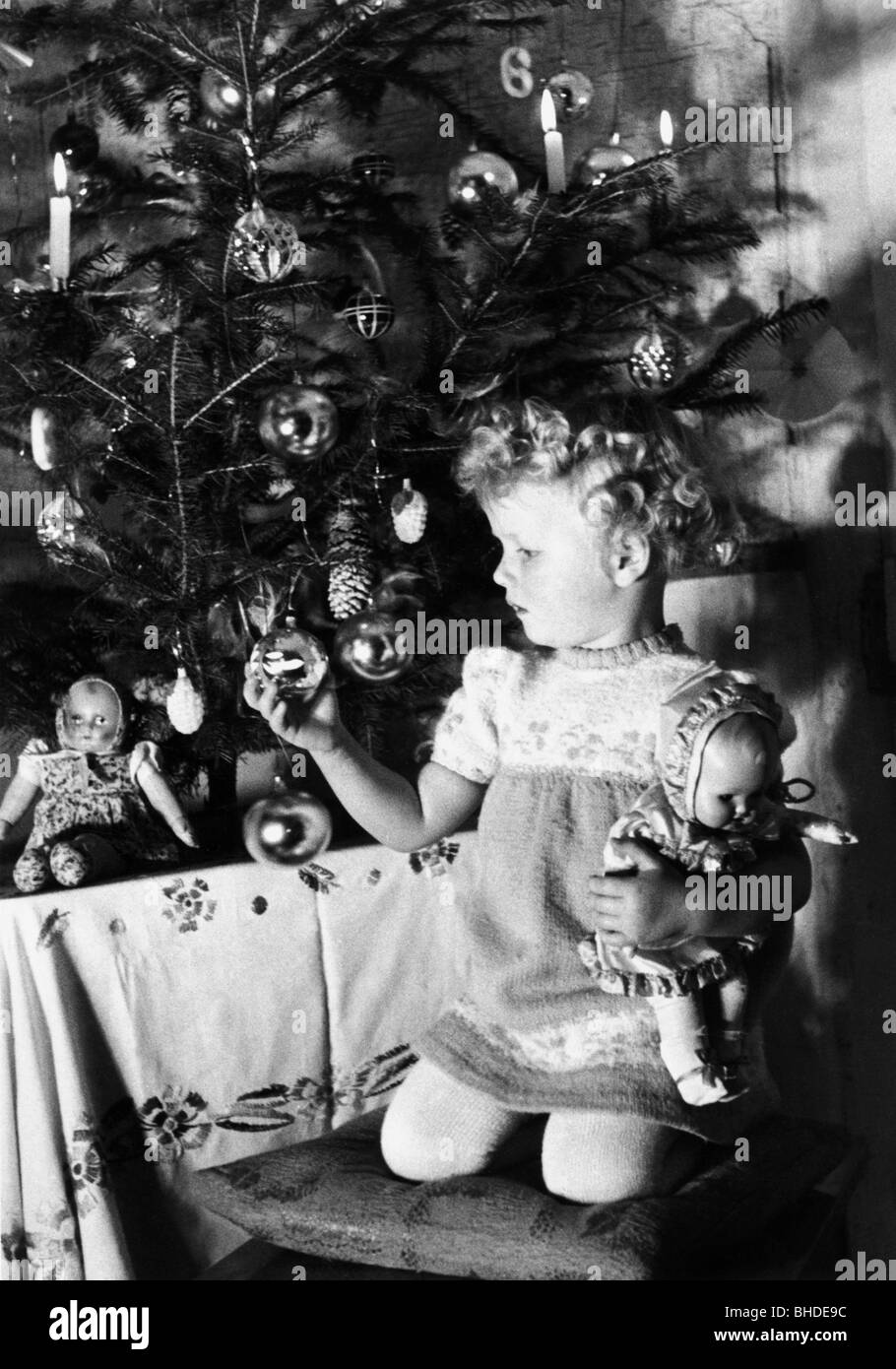Christmas, distribution of  presents, little girl beside a Christmas tree, 1940, Stock Photo