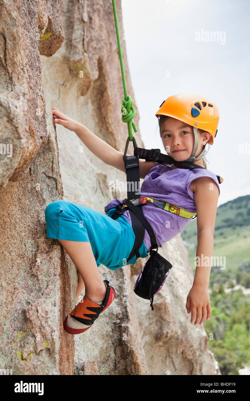 Mixed race girl rock climbing Stock Photo