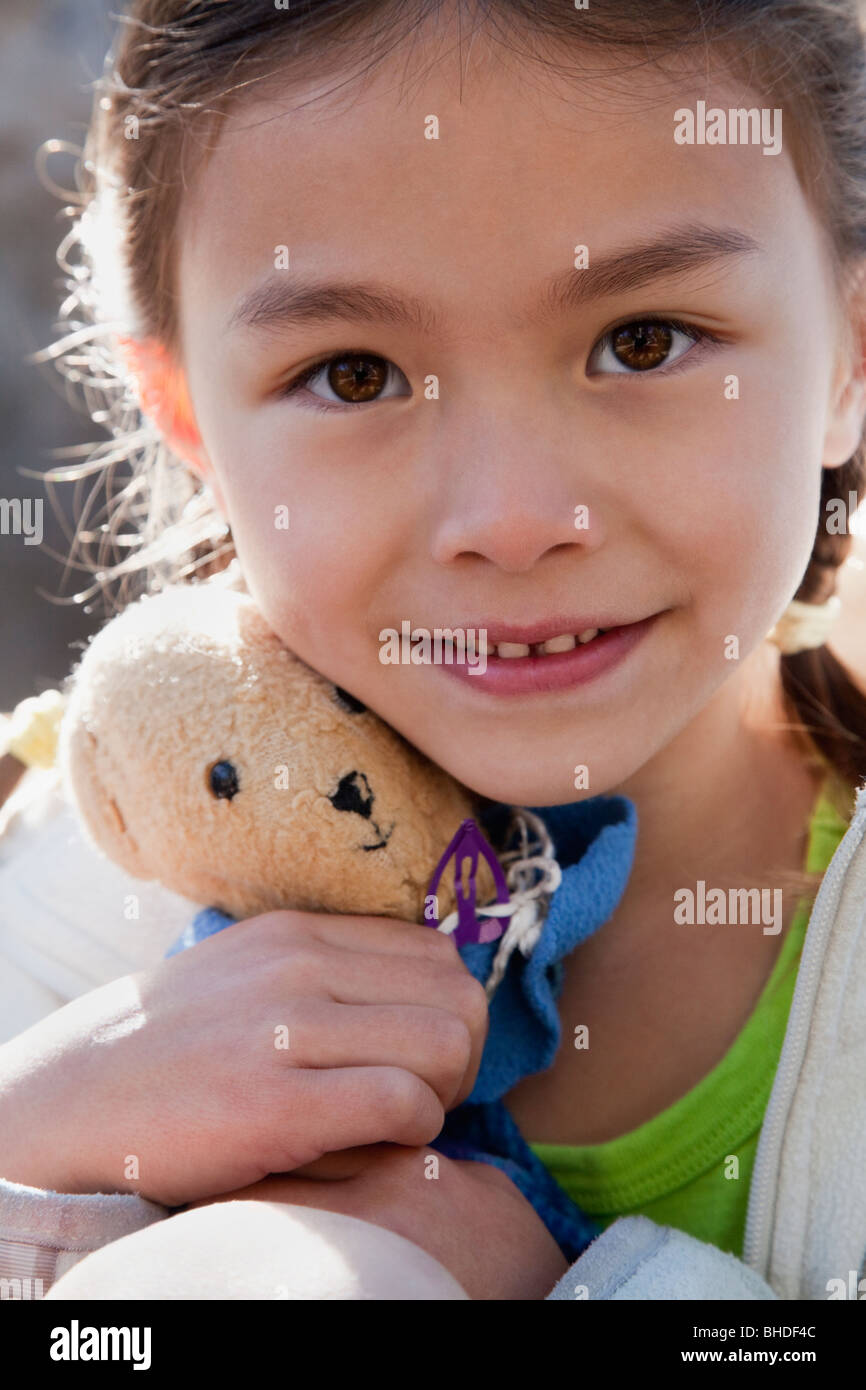 Mixed race girl holding teddy bear Stock Photo