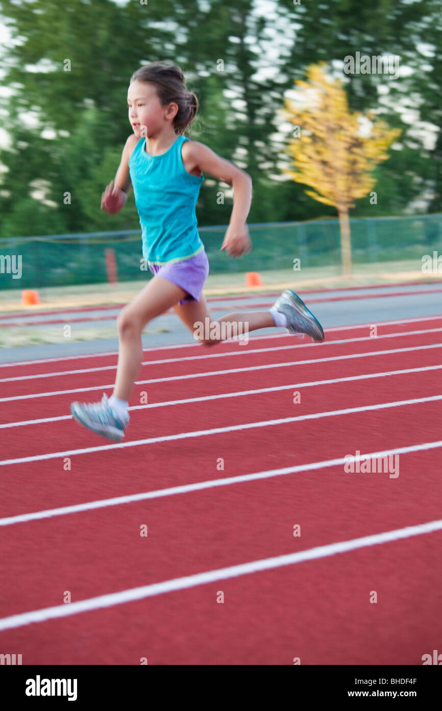 Mixed race girl running on track Stock Photo
