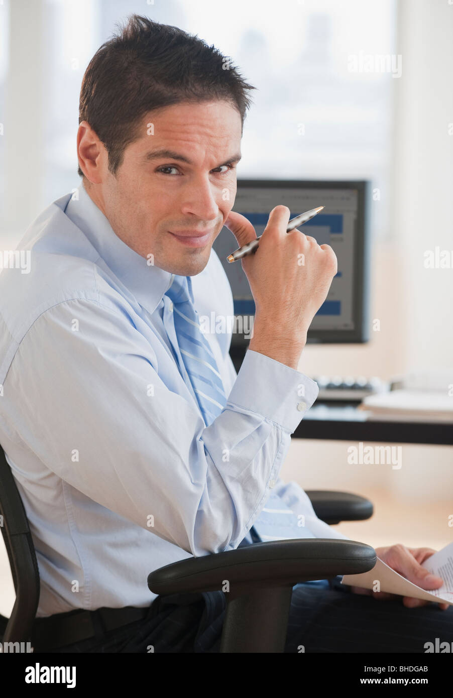 Hispanic businessman sitting at desk Stock Photo