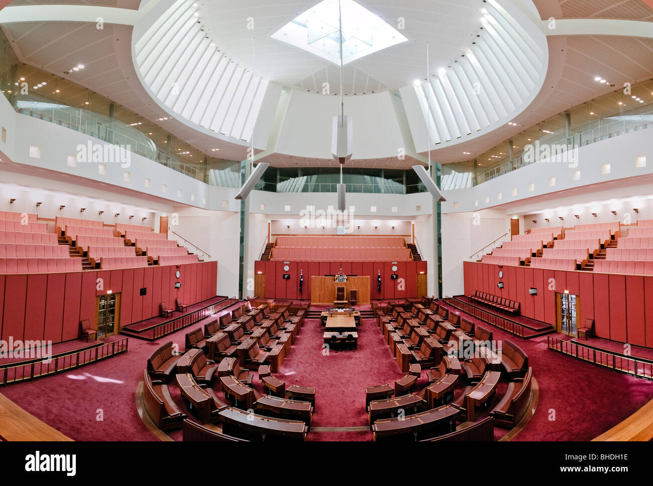 CANBERRA, Australia - The Senate building follows the colour scheme of the House of Lords, decorated in red, this time muted to tints of ochre, suggesting the earth and the colours of the outback. Parliament House is the meeting place of the Parliament of Australia. It is located in Canberra, the capital of Australia. It was opened on 9 May 1988 by Queen Elizabeth II, Queen of Australia.[1] Its construction cost was over $1.1 billion. At the time of its construction it was the most expensive building in the Southern Hemisphere. Prior to 1988, the Parliament of Australia met in the Provisional  Stock Photo