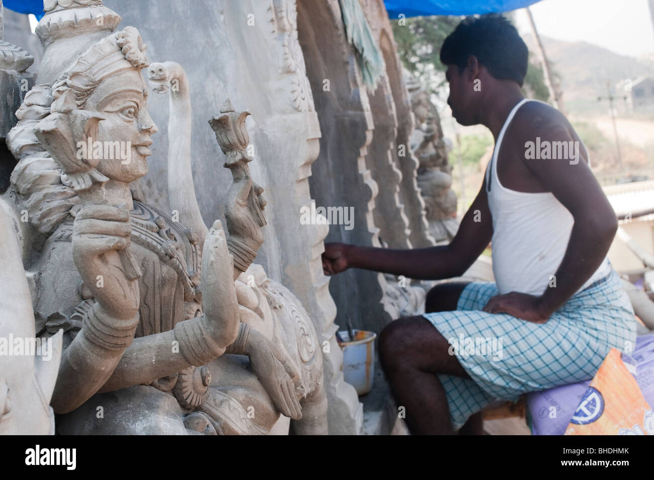 Indian man creating concrete temple deity sculptures on a hindu temple roof. Andhra Pradesh, India Stock Photo