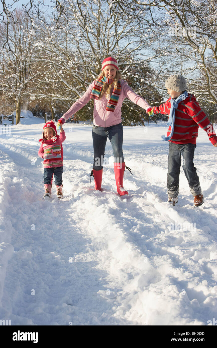 Mother Walking With Children Through Snowy Landscape Stock Photo