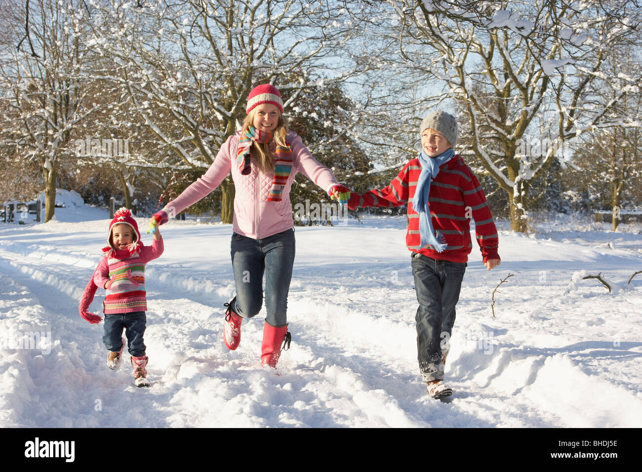 Mother Walking With Children Through Snowy Landscape Stock Photo