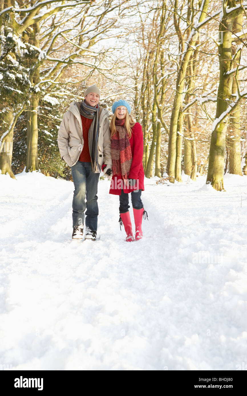 Couple Walking Through Snowy Woodland Stock Photo