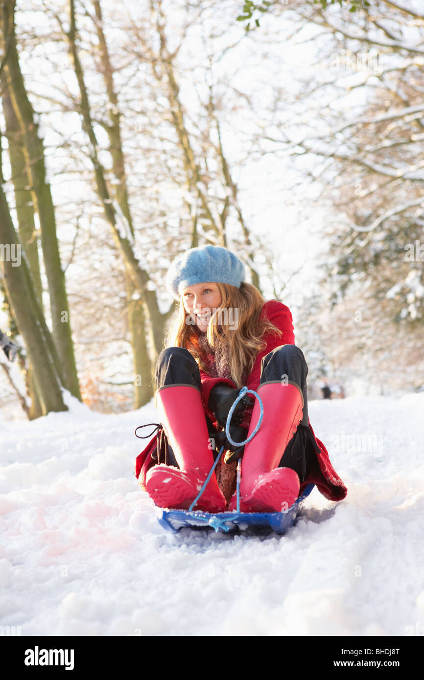 Woman Sledging Through Snowy Woodland Stock Photo