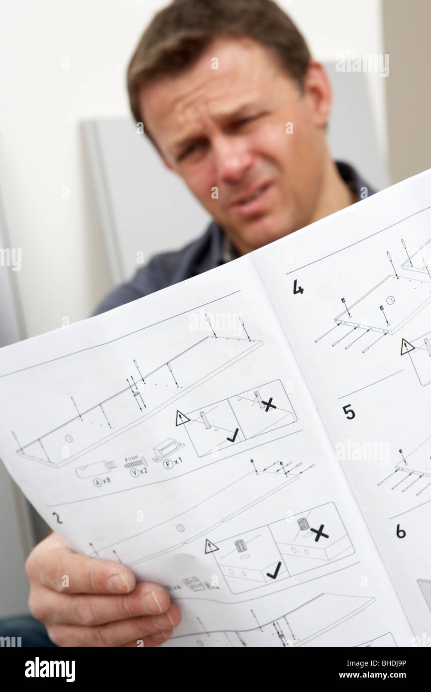 Puzzled Man Reading Assembly Instructions For Flat Pack Furniture Stock