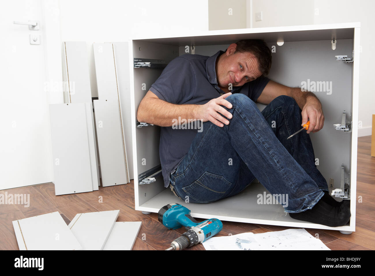 Man Trapped Whilst Assembling Flat Pack Furniture Stock Photo