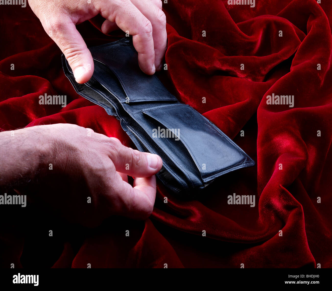 Hands opening empty leather wallet on red velvet Stock Photo