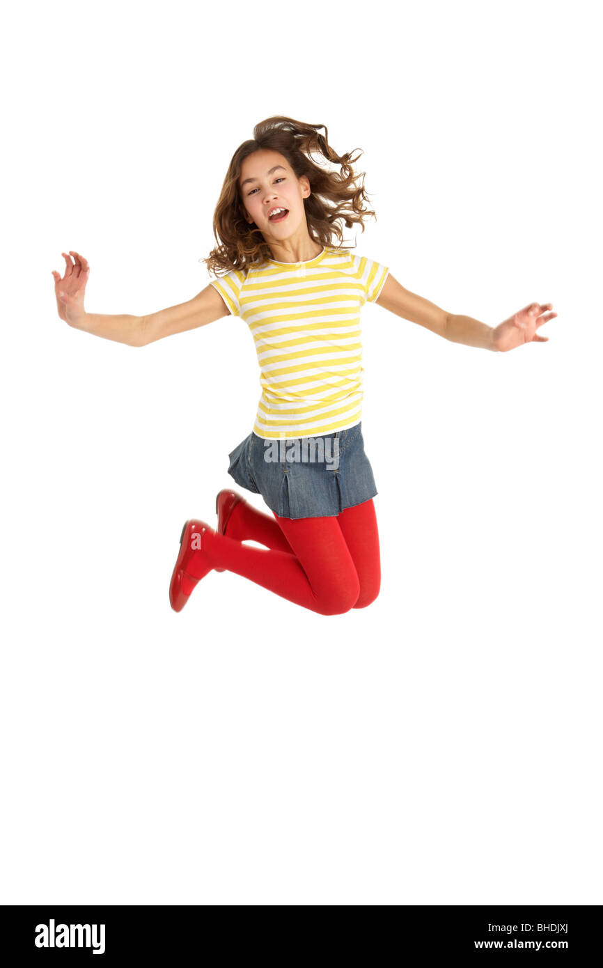 Mid Air Studio Shot Of Young Girl Jumping In Air Stock Photo