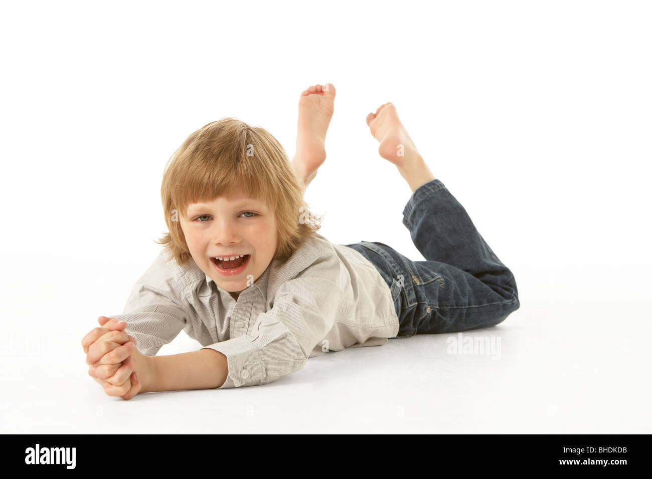 Young Boy Lying On Stomach In Studio Stock Photo