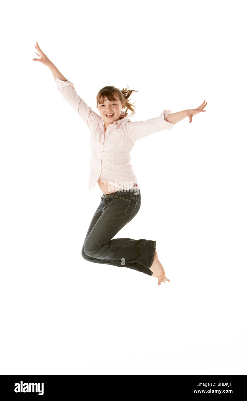 Studio Shot Of Young Girl Jumping In Studio Stock Photo