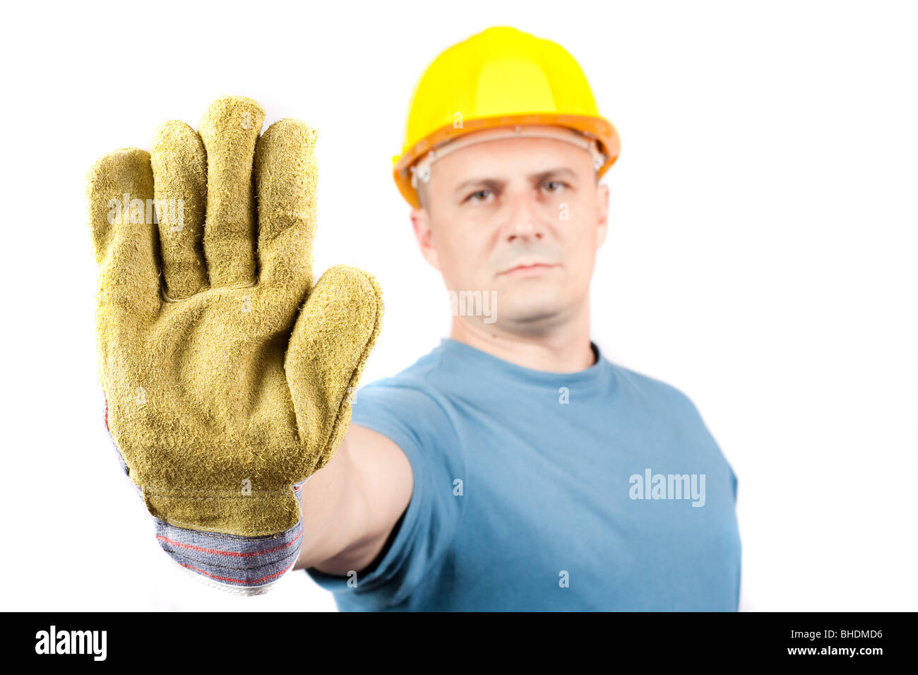 Строитель показывает стоп. Мужчина в рабочей форме испуг. Неквалифицированные специалисты стоковое картинки. Работник в серых рабочих перчатках