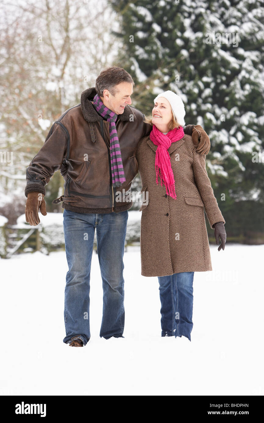 Senior Couple Walking In Snowy Landscape Stock Photo