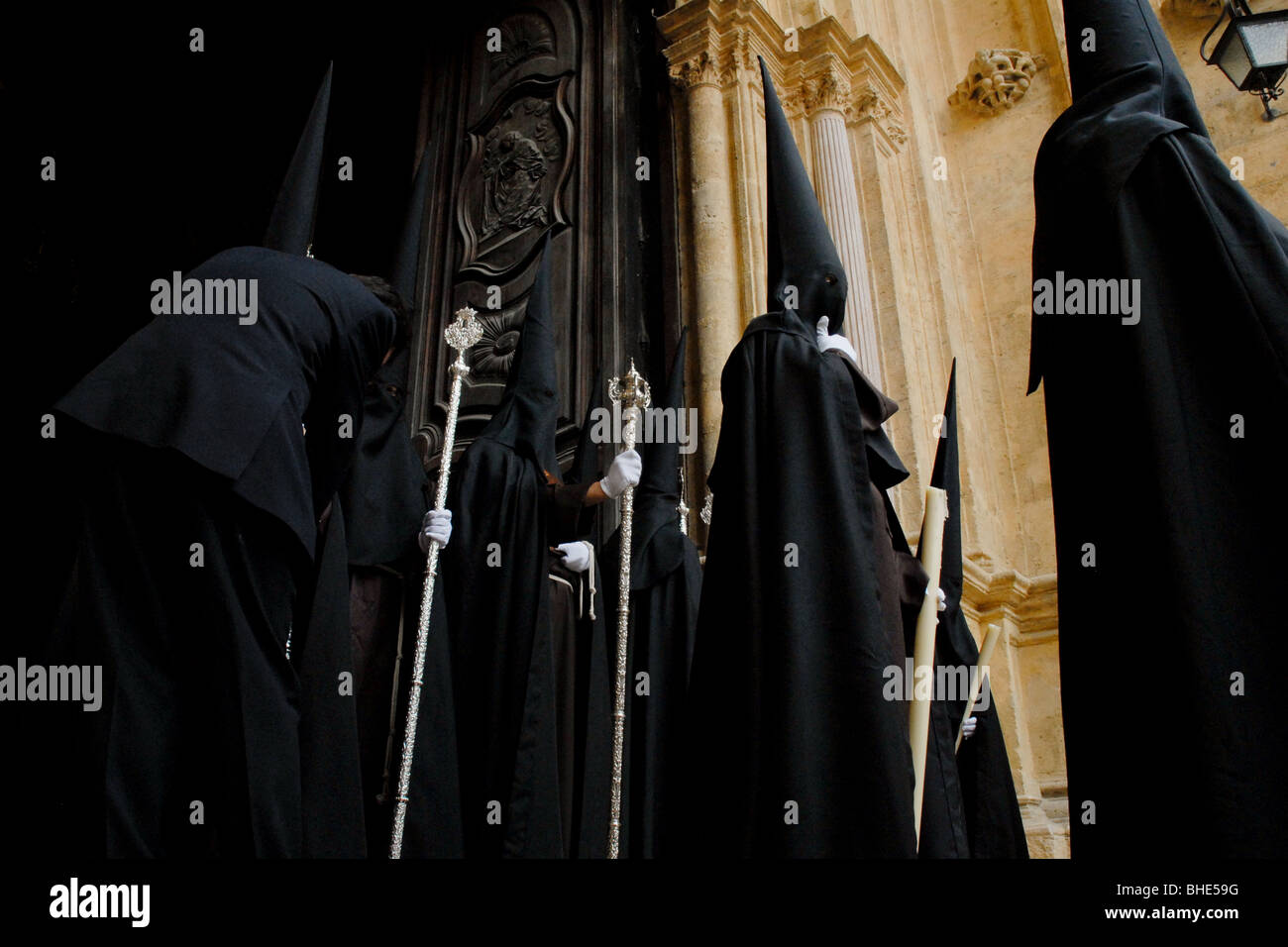 The brotherhood members in their traditional penitent robes stand in ...