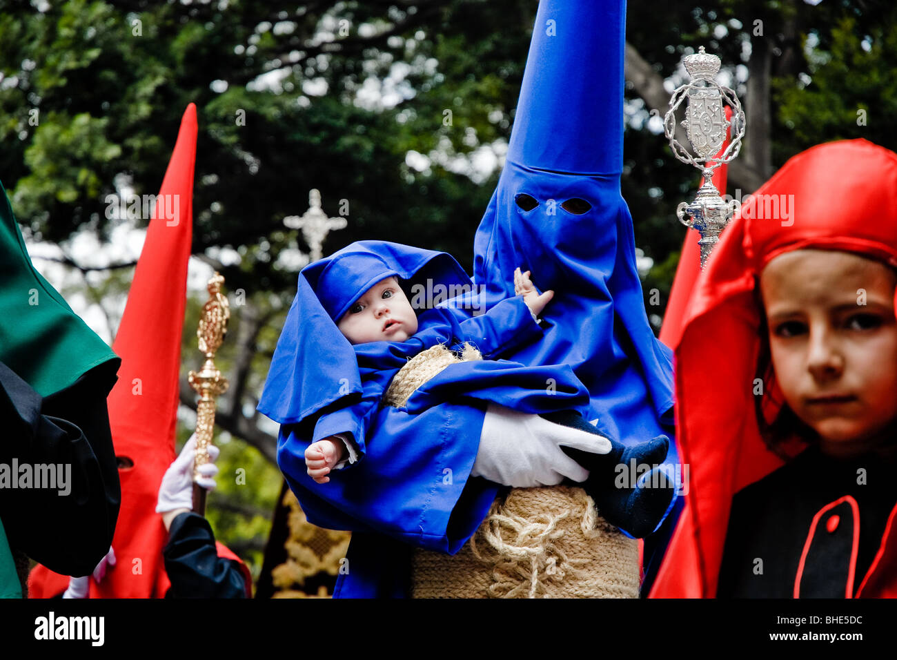 The Holy Week penitent carries a small child dressed in the penitent ...