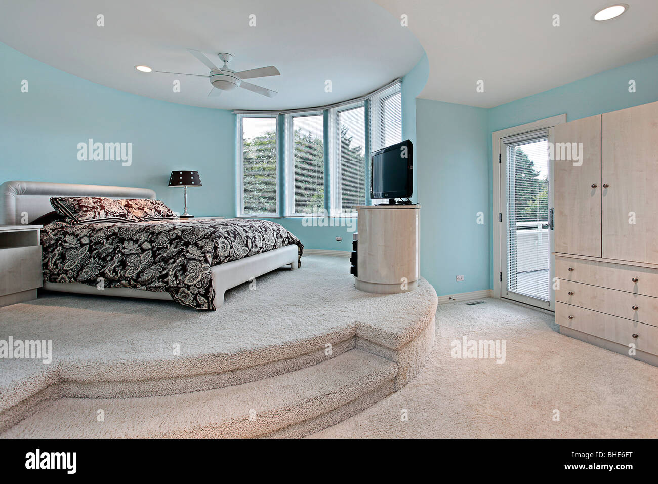 Bedroom In Upscale Home With Step Up Sleeping Area Stock Photo