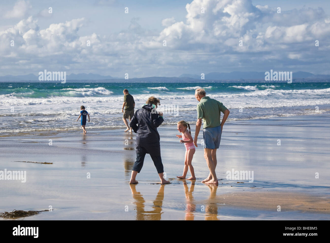 Senior woman and man with little girl on the beach of Fanore, County Clare, Ireland. Stock Photo