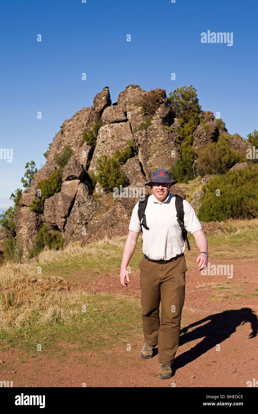 A man in a broad brimmed hat walks on one of the mountain peaks of Madeira, Portugal. Stock Photo