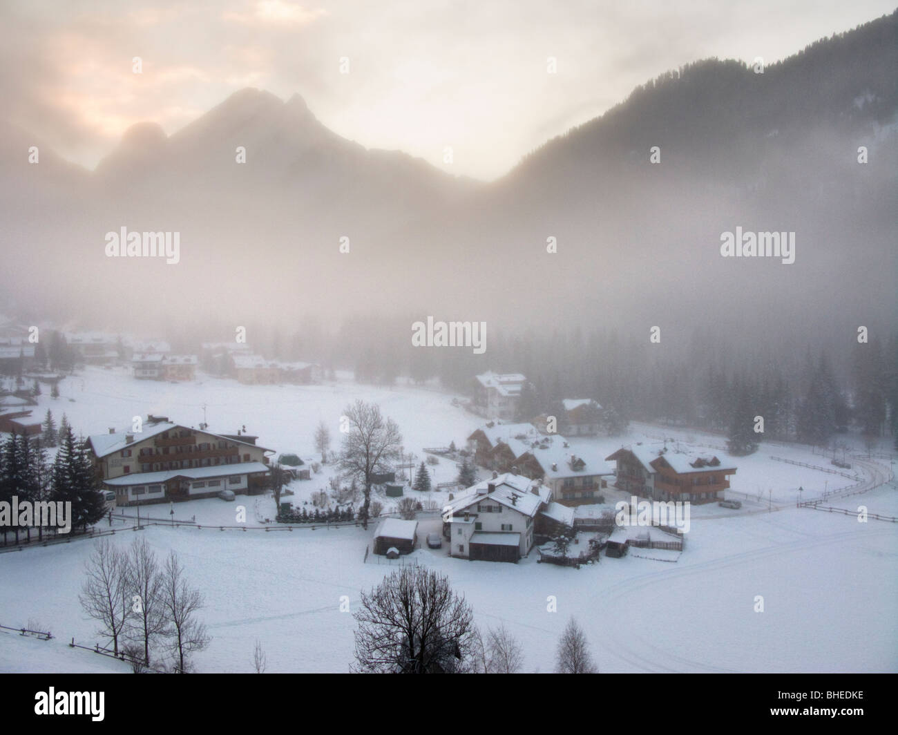 Canazei, Val di Fassa, Dolomites, Italy. Ski resort on Sella Ronda ski circuit. Early morning mist in valley. Stock Photo
