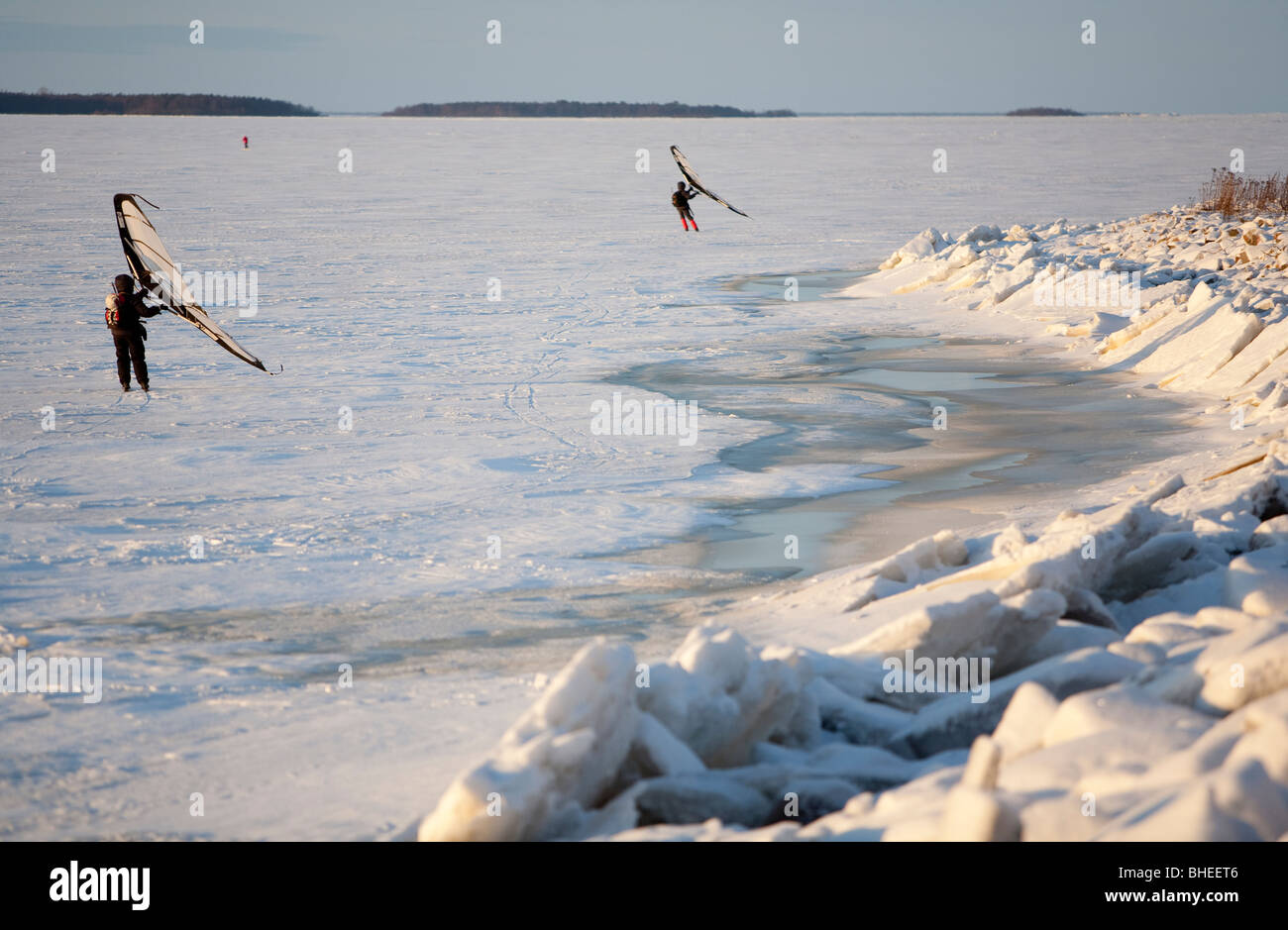 People skiing on sea ice at Wintertime using a kitewing, Finland Stock Photo