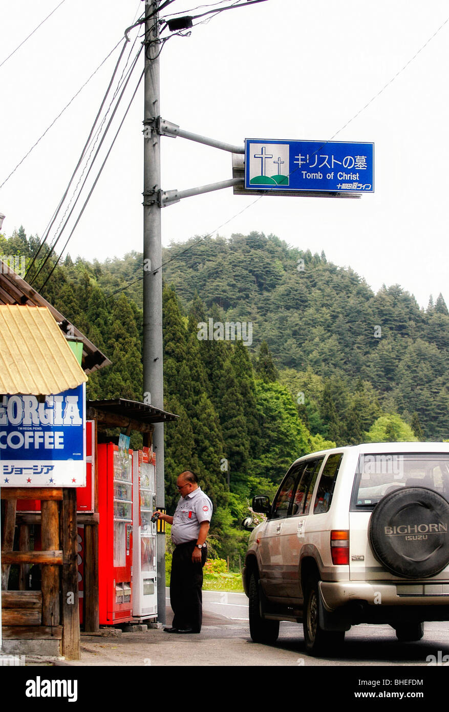 A man buys a drink from a vending machine located by the entrance to Christ's tomb in Shingo Village, Japan Stock Photo