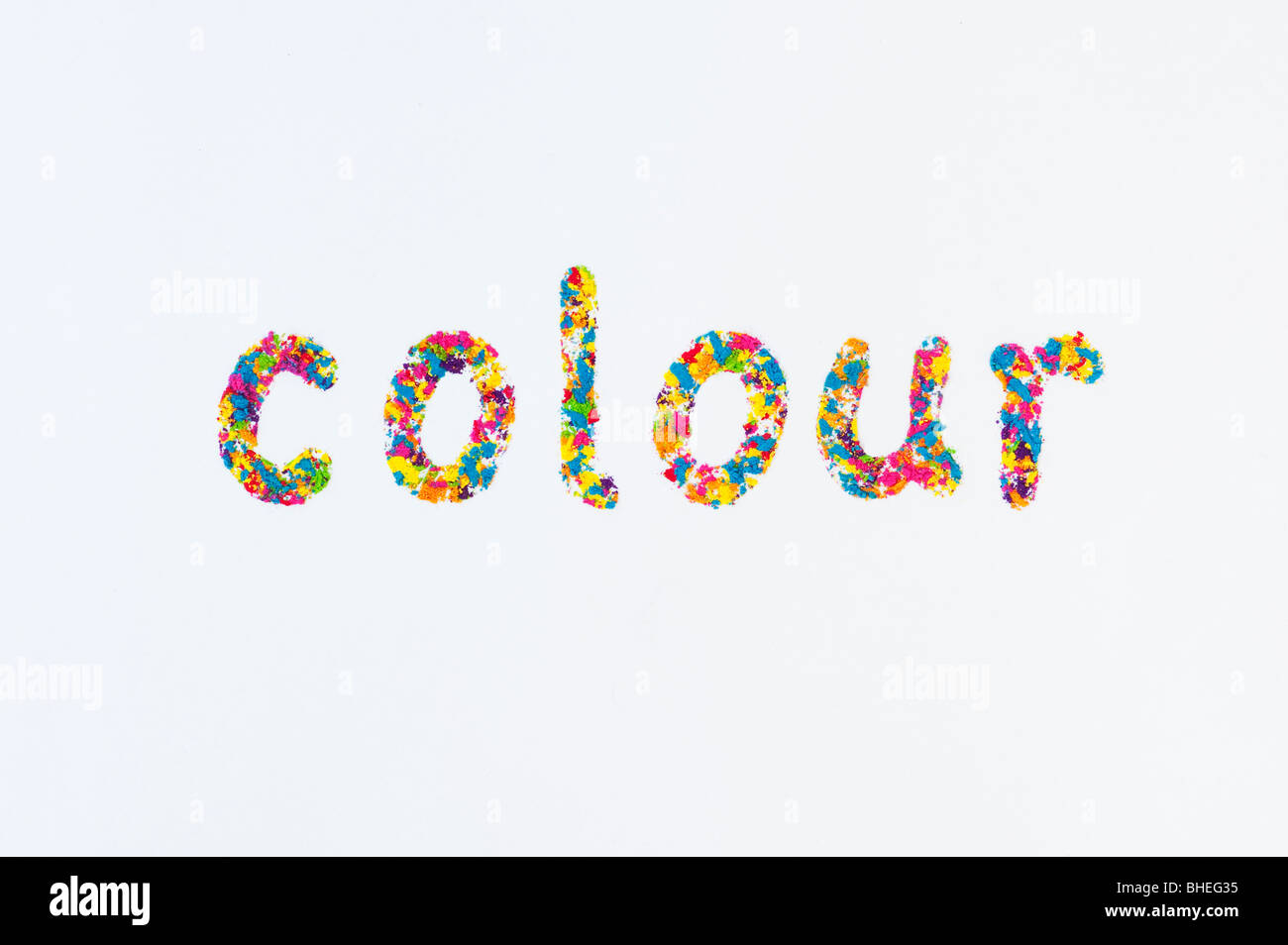 The word COLOUR (English spelling) , spelt using multi coloured powder on white background Stock Photo