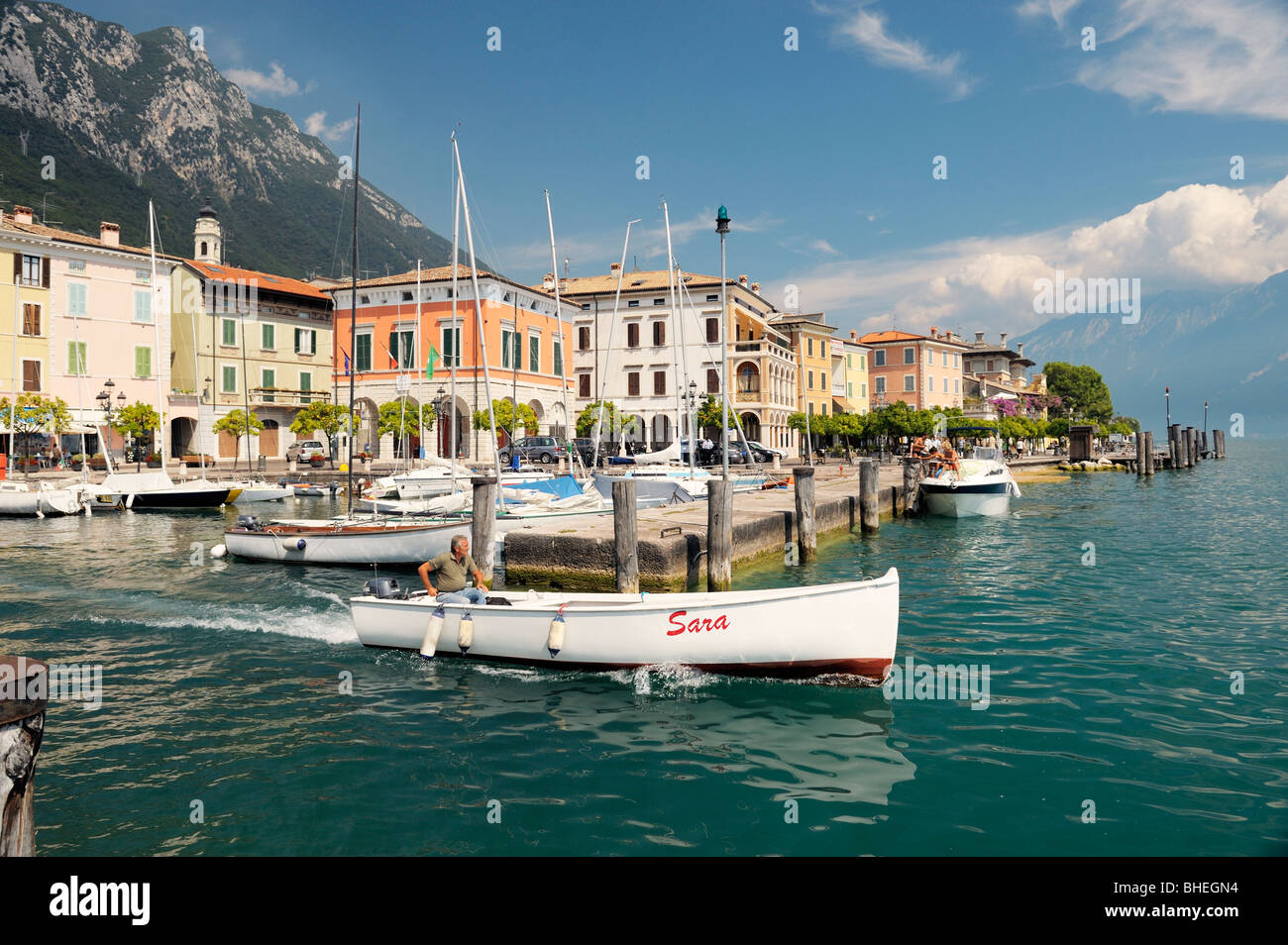 The holiday resort town of Gargnano on Lake Garda, Lombardy, Italy. Boat leaving the harbour. Lago di Garda. Stock Photo