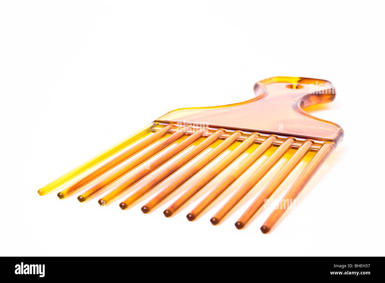Wide plastic afro comb from low viewpoint isolated against white background. Stock Photo